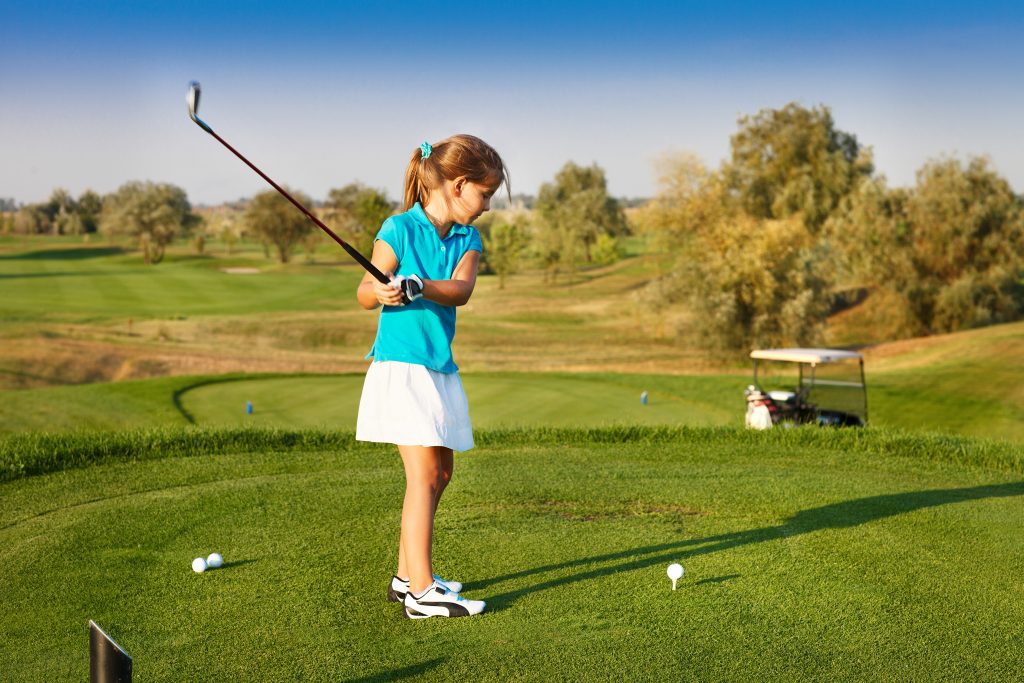 A girl about to strike a golf ball