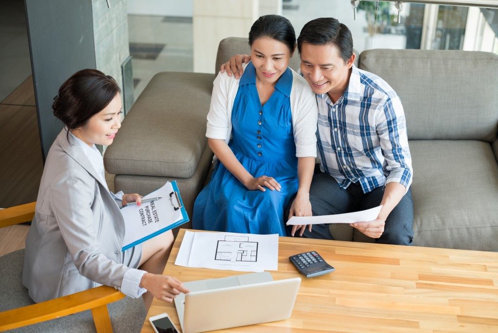 asian couple talking to a businesswoman