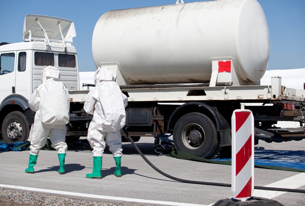 two men in safety uniform checking on the truck transporting chemical